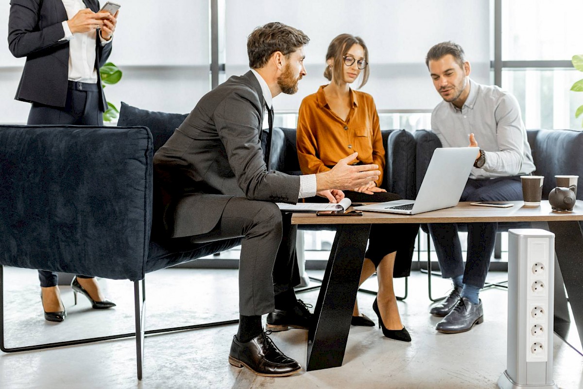 Professional team in meeting around laptop