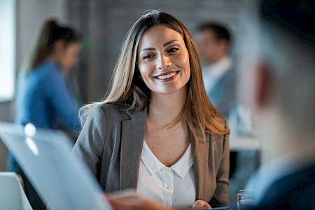 Female professional smiling looking at computer screen