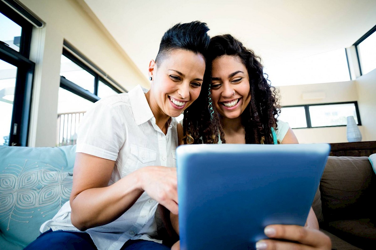 female couple looking at laptop smiling