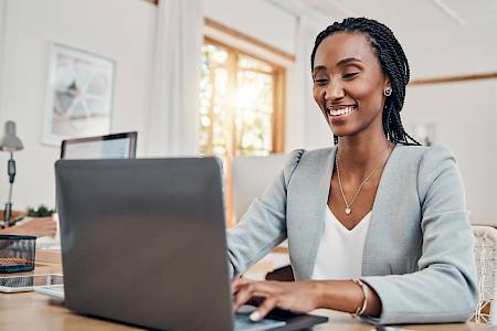 Female professional smiling looking at computer screen