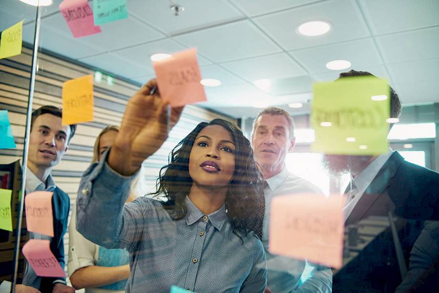 Project team looking at project board with sticky notes