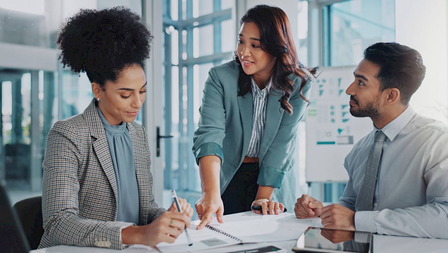 professional male and female team looking at laptop screen smiling in office setting